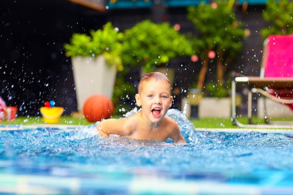 Barn som badar i en pool på sommaren